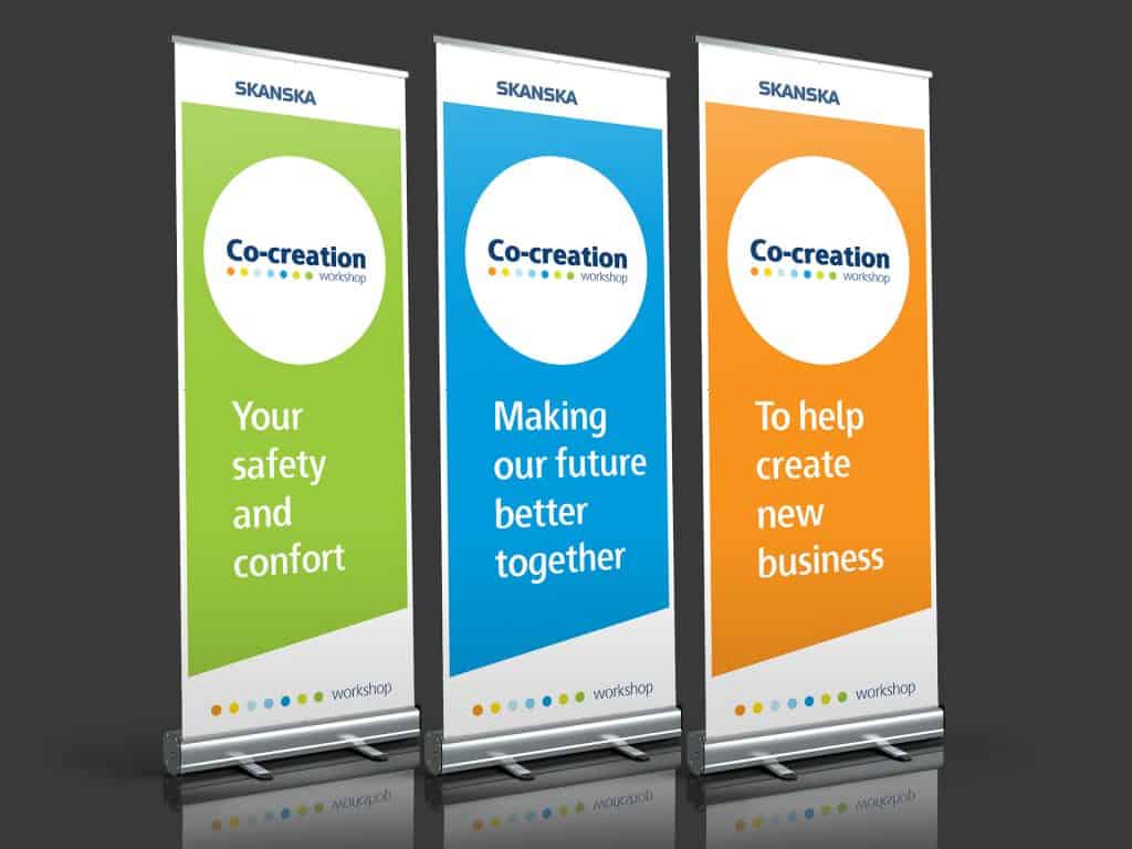 Skanska Co-creation Workshop roll-up banners in green, blue and orange with workshop messaging.
